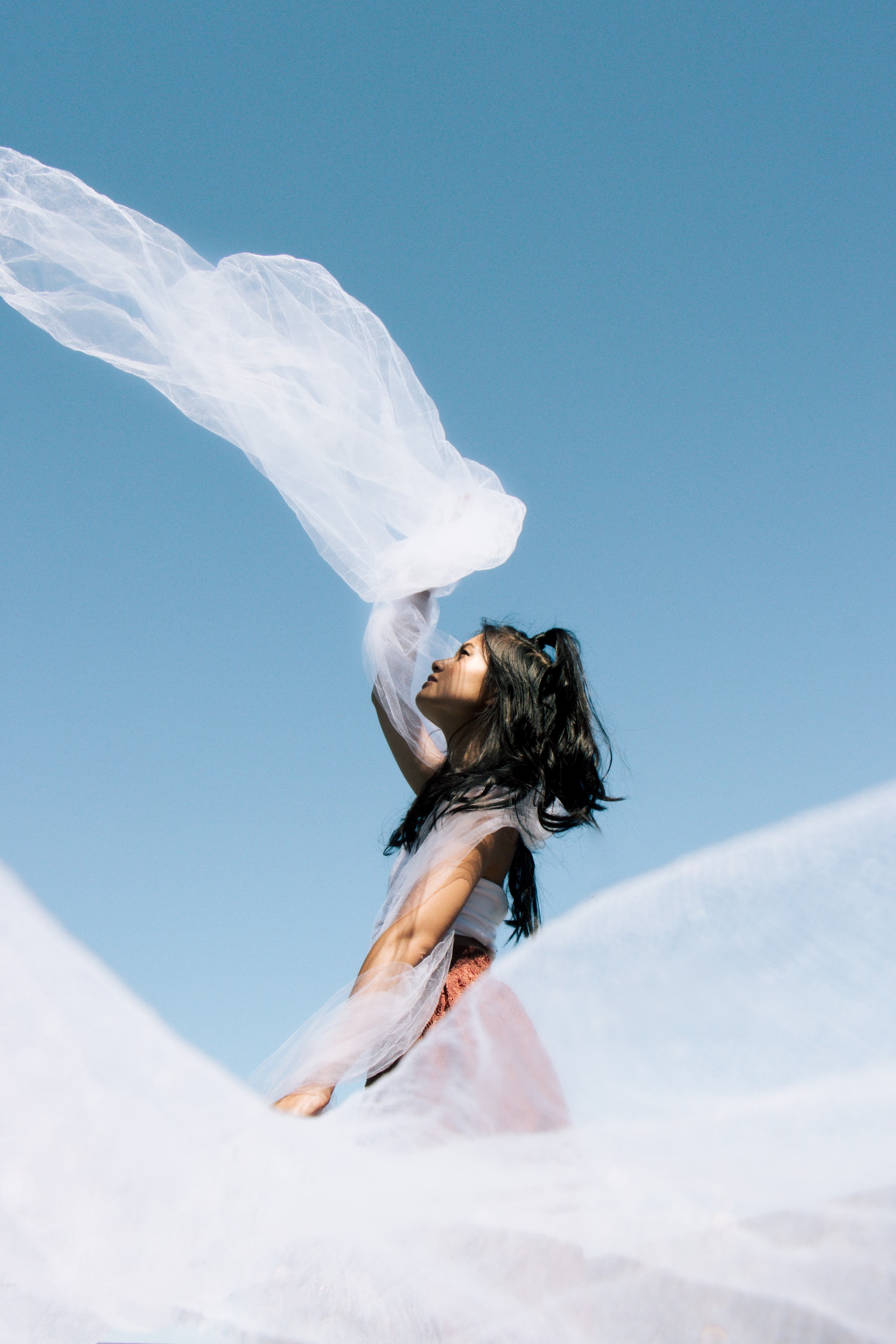 Woman with white linen twirling during a sunny day